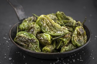 Portion of fresh Pimientos de Padron close-up shot, selective focus