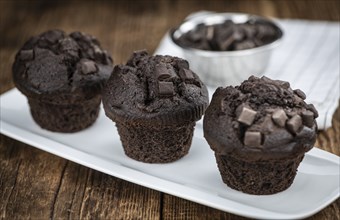 Vintage wooden table with Chocolate Muffins (selective focus, close-up shot)