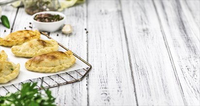 Portion of healthy Empanadas on an old wooden table (selective focus, close-up shot)