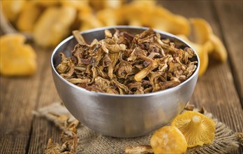 Dried Chanterelles on an old wooden table as detailed close-up shot, selective focus