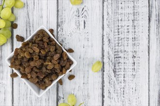 Vintage wooden table with Raisins (selective focus, close-up shot)