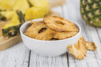 Pineapple rings (dried) on rustic wooden background as close-up shot