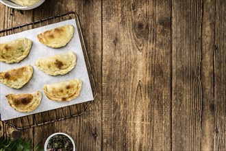Portion of healthy Empanadas on an old wooden table (selective focus, close-up shot)