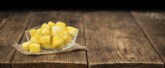 Sliced Pineapple on an old wooden table as detailed close-up shot, selective focus