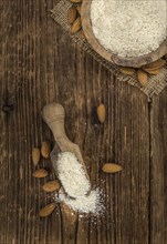 Portion of fresh Powdered Almonds on an old wooden table
