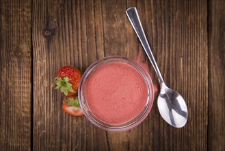 Strawberry powder as high detailed close-up shot on a vintage wooden table, selective focus