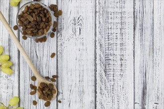 Vintage wooden table with Raisins (selective focus, close-up shot)