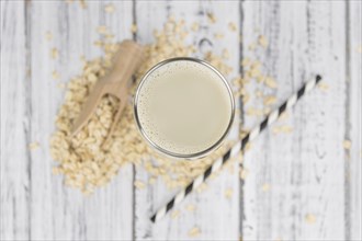 Wooden table with Oat Milk (detailed close-up shot, selective focus)