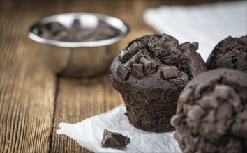 Vintage wooden table with Chocolate Muffins (selective focus, close-up shot)