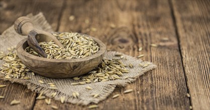 Old wooden table with fresh Oat (close-up shot, selective focus)