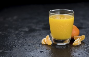 Fresh made Tangerine Juice on a vintage slate slab (selective focus)