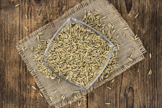 Old wooden table with fresh Oat (close-up shot, selective focus)