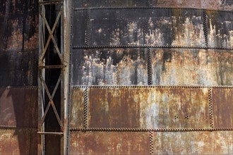 Riveted walls of an old gas storage tank, covered with rust, industrial monument Athens Gasworks