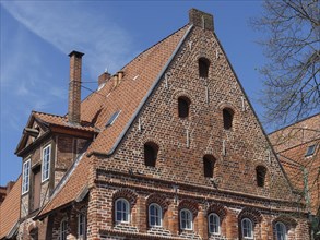 Medieval brick gabled house with characteristic windows and blue sky, lüneburg, germany