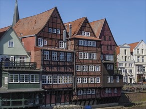 Closely spaced half-timbered houses on a sunny day, bordering the river, lüneburg, germany