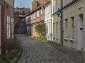 Cobbled street in a historic old town lined with half-timbered houses and beautiful windows,