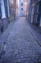 Narrow cobbled alley with historic buildings and shutters, Leer, East Frisia, Germany, Europe