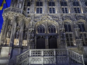 Detailed Gothic entrance façade of a historic building at night, Ghent, Belgium, Europe