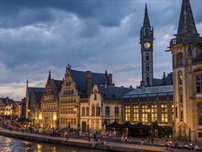 Waterfront promenade with historic buildings and many people at dusk, Ghent, Belgium, Europe