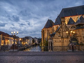 Illuminated church and houses on canal and bridge at night, Ghent, Belgium, Europe
