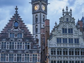 Historic facades and a Gothic-style clock tower at dusk, Ghent, Belgium, Europe
