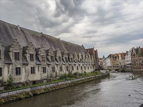 View of the river with historic buildings and grey sky, Ghent, Belgium, Europe