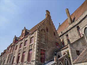 Historic brick building with many windows in Bruges on a sunny day, Bruges, Belgium, Europe