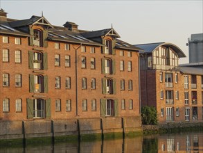 Brick building on a canal reflected in the calm water, clear windows, husum, schleswig-holstein,