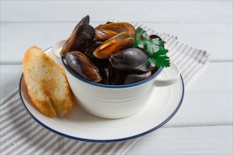 Fresh, Boiled mussels, Black Sea, with white bread, on a white wooden table, no people