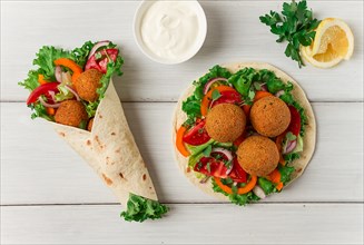 Tortillas, wrapped falafel balls, with fresh vegetables, vegetarian healthy food, on a wooden white