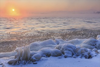 Shore of a lake covered with ice at sunrise, winter, Lake Starnberg, Alpine foothills, Upper