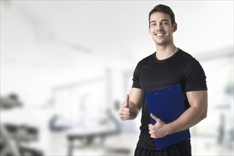 Personal trainer in a gym holding a notepad