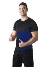 Personal trainer in a gym holding a notepad isolated in white