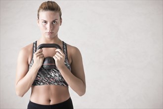 Fit woman working out with a kettlebel and similingl, isolated in white