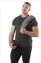 Man holding a protein shake after a workout in the gym, isolated in white