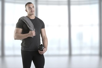 Man holding a protein shake after a workout in the gym