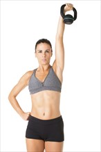 Fit woman working out with a kettlebell, isolated in white