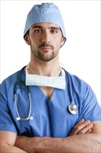 Young male surgeon with scrubs and a stethoscope, isolated in white