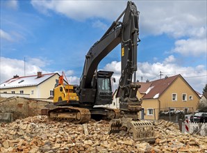 Excavator on the rubble of a demolished building