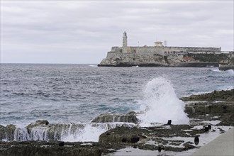 Havana, Cuba, Central America, sea coast with breaking waves and a lighthouse on a rock, Central