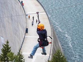 Child on zipline above reservoir dam, Barrage de Emosson, Finhaut, Switzerland, Europe