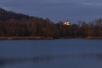 Illuminated church of Schaefstall near Donauworth above a lake in Bavaria