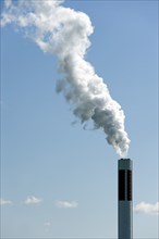White smoke out of a smokestack in front of blue sky