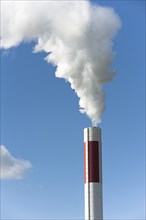 White smoke out of a smokestack in front of blue sky