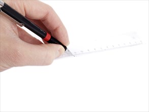 Someone drawing a line against a ruler onto a white paper