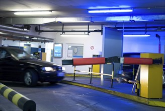 Car driving in a parking garage with blue light