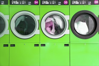 Green clothes washers in a laundrette