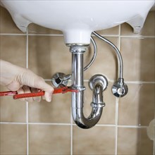 Hand of a plumber fixing a drain