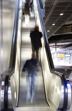 Blurred people on an escalator in a railway station