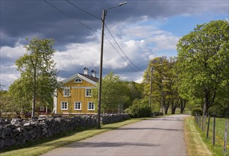 Old, traditional wooden house in southern Sweden, Smaland, on a spring day. Old yellow farm house